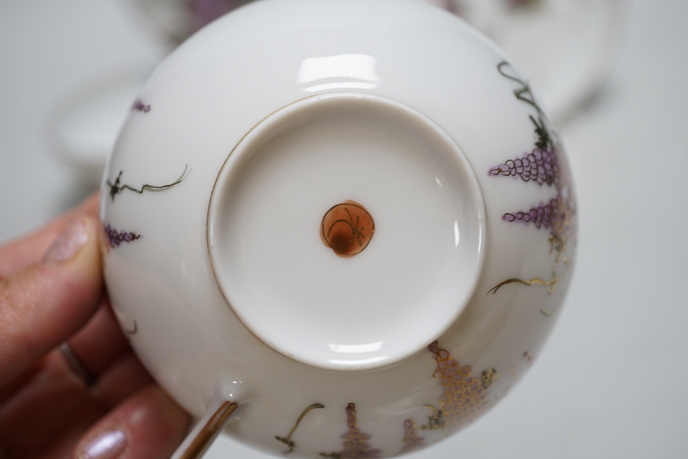 A Japanese part tea service with wisteria decoration, comprising of eight cups, eleven saucers and twelve tea plates